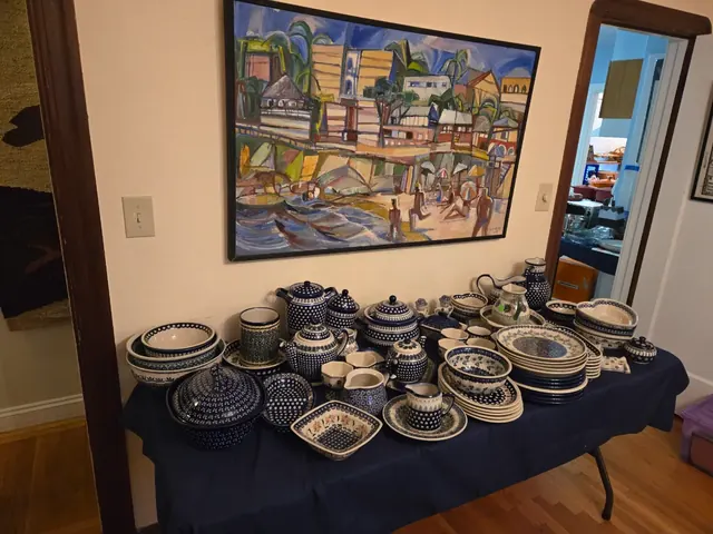 Polish pottery service laid out beneath original art